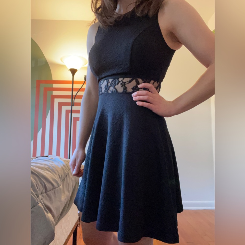 Black, textured material dress with lace peek through at the waist. Form fitting
